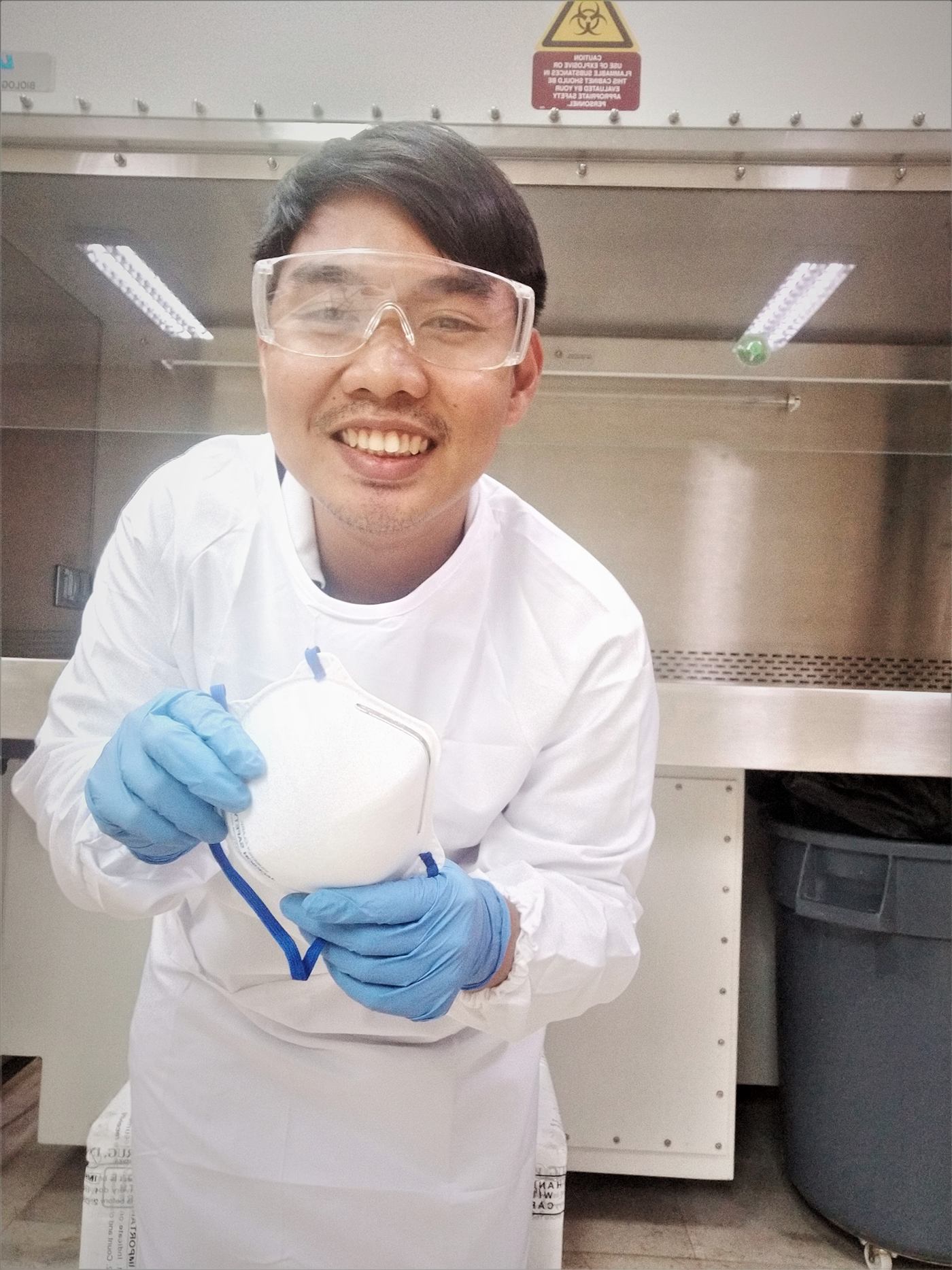 Jolas in full PPE at a biosafety cabinet